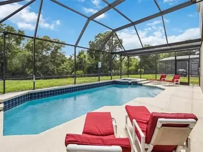 a swimming pool with two lounge chairs and a pool at WP8167SPD – Spacious 6-Bed Oasis with Pool near Disney in Kissimmee