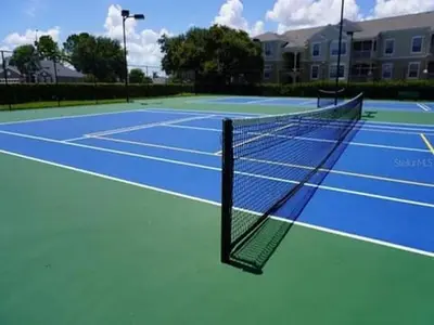 a tennis court with a net on top of it at WP8167SPD – Spacious 6-Bed Oasis with Pool near Disney in Kissimmee