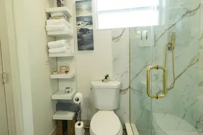 a bathroom with a toilet and a glass shower at 10 Minutes from Universal - Relaxing Guest Suite in Orlando