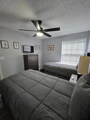 a bedroom with two beds and a ceiling fan at Great condo getaway! in Kissimmee