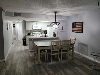 a kitchen and dining room with a table and chairs at Great condo getaway! in Kissimmee