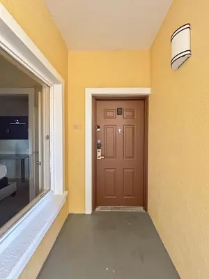 a hallway with a brown door and a window at Modern & Spacious 3 Bedroom Retreat! in Orlando