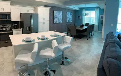 a kitchen and living room with a table and chairs at To Infinity and Beyond – Storey Lake Resort by Shine Villas condo in Kissimmee