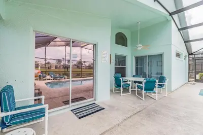 a house with a patio with a table and chairs at Private Heated Pool near Disney in Kissimmee