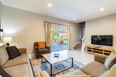a living room with two couches and a tv at 15min to Disney · Modern Home Hot Tub in Kissimmee