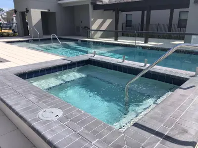 a large swimming pool with a hot tub at Themed Bedrooms BBQ Near Disney in Kissimmee