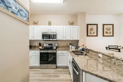 a kitchen with white cabinets and a counter top at Family Home Near Disney – Modern Bright in Kissimmee