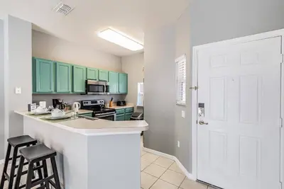 a kitchen with green cabinets and a counter top at Family Townhome Near Disney w Heated Pool in Kissimmee