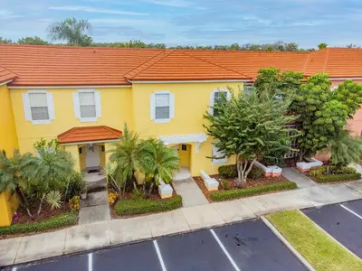 a yellow house with an orange roof at Cozy 3BR Townhome Near Disney in Kissimmee in Kissimmee