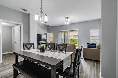 a dining room and living room with a table and chairs at Cozy 3BR Townhome Near Disney in Kissimmee in Kissimmee