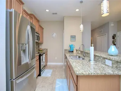 a large kitchen with a stainless steel refrigerator at Cozy 3BR Villa 15min from Disney Heated Pool in Kissimmee