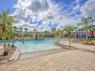 a swimming pool at a resort with palm trees at Cozy 3BR Villa 15min from Disney Heated Pool in Kissimmee
