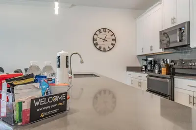 a kitchen with a counter and a clock on the wall at Disney 15min - Private Pool BBQ in Kissimmee