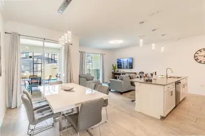 a kitchen and living room with a table and chairs at Disney 15min - Private Pool BBQ in Kissimmee