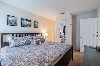 a bedroom with a large bed and a door at Lake Berkley Getaway – 5BR Resort Home in Kissimmee