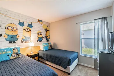 a bedroom with a bed and a wall with minions at Lake Berkley Getaway – 5BR Resort Home in Kissimmee