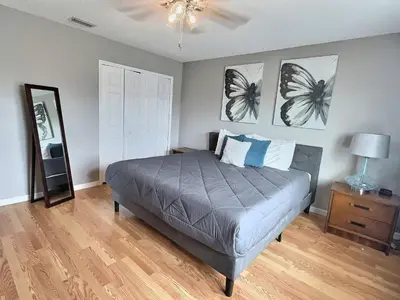 a bedroom with a bed with two pictures on the wall at Lake Berkley Getaway – 5BR Private Pool in Kissimmee