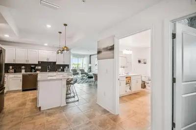 an open kitchen and living room with white cabinets at Luxury Resort · Pool Lazy River in Kissimmee