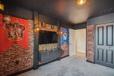 a room with a wall with a tv and a brick wall at Disney Retreat · Pool Themed Bedrooms in Kissimmee