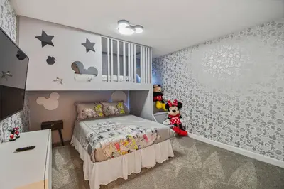 a small bedroom with a bed and a wall with stars at Disney Retreat · Pool Themed Bedrooms in Kissimmee