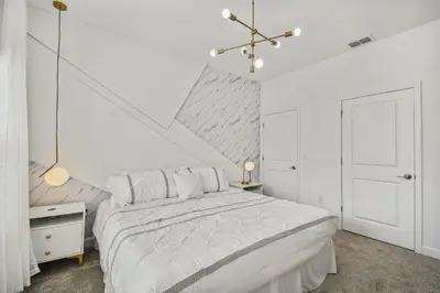 a white bedroom with a large white bed and a chandelier at Disney Retreat · Pool Themed Bedrooms in Kissimmee