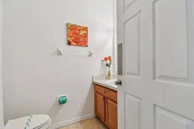 a bathroom with a toilet and a vase of flowers at Family Stay Close to Disney Parks in Kissimmee