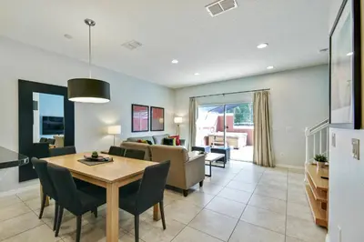 a dining room and living room with a table and chairs at Encantada Resort 15min Disney in Kissimmee