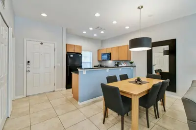 a kitchen and dining room with a table and chairs at Encantada Resort 15min Disney in Kissimmee
