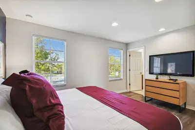 a bedroom with a bed and a flat screen tv at Encantada Resort 15min Disney in Kissimmee