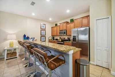 a kitchen with a row of bar stools at Orlando Getaway w Heated Pool in Kissimmee