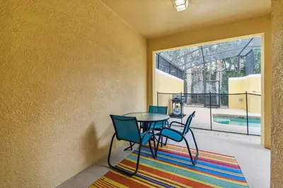 a dining room with a table and chairs on a rug at Orlando Getaway w Heated Pool in Kissimmee