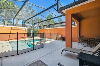 a patio with a pool and a table and chairs at Disney Retreat – 15min to Parks in Kissimmee