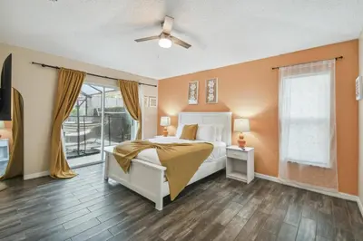 a bedroom with a bed and a ceiling fan at Family Retreat near Disney in Kissimmee