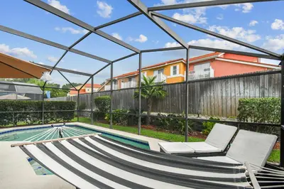 a view of a swimming pool with two lounge chairs and a house at Family Retreat near Disney in Kissimmee