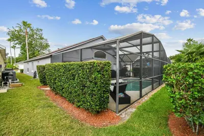a glass house with a pool in a yard at Family Retreat near Disney in Kissimmee