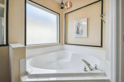 a white tub in a bathroom with a window at Family Retreat near Disney in Kissimmee