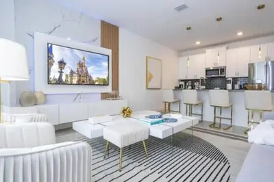 a living room with white furniture and a kitchen at Family Retreat near Disney in Kissimmee