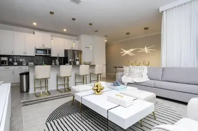 a living room with a couch and a kitchen at Family Retreat near Disney in Kissimmee