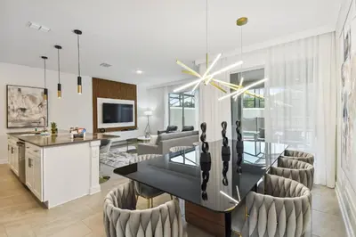 a dining room and living room with a dining table and chairs at 4BR Townhome Near Disney Water Park in Kissimmee