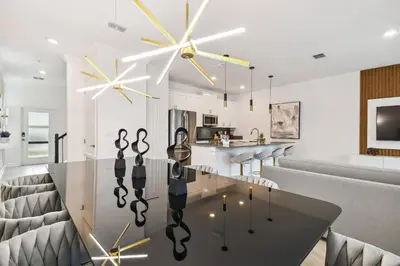 a dining room with a glass table and chairs at 4BR Townhome Near Disney Water Park in Kissimmee