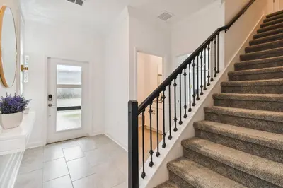 a staircase in a home with white walls and carpeted floors at 4BR Townhome Near Disney Water Park in Kissimmee