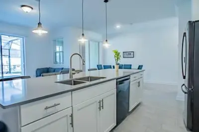 a kitchen with a sink and a refrigerator at Orlando Retreat – 4BR Home Near Disney in Kissimmee