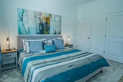 a bedroom with a large bed with blue pillows at Orlando Retreat – 4BR Home Near Disney in Kissimmee