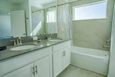 a white bathroom with two sinks and a mirror at Orlando Retreat – 4BR Home Near Disney in Kissimmee