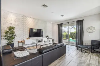 a living room with a couch and a flat screen tv at Luxury Family Retreat Near Disney in Kissimmee