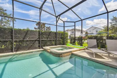 a swimming pool with two chairs and a house at Luxury Family Retreat Near Disney in Kissimmee