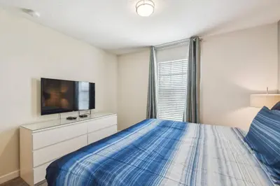 a bedroom with a bed and a flat screen tv at Luxury Family Retreat Near Disney in Kissimmee