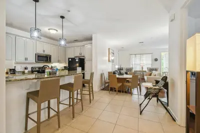 a kitchen and living room with a table and chairs at Orlando Stay Near Universal Studios in Orlando