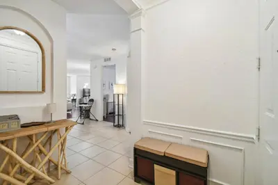 a living room with a bench and a mirror at Orlando Stay Near Universal Studios in Orlando