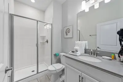 a white bathroom with a shower and a toilet at Orlando Stay Near Disney with Private Pool in Kissimmee